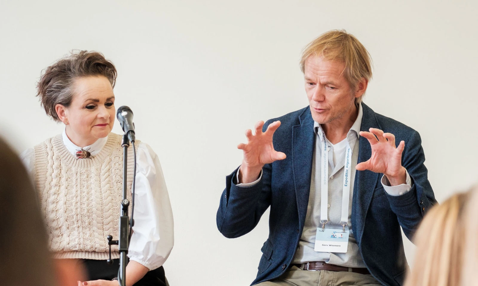 Staatssecretaris Alexandra van Huffelen en Serv Wiemers zittend op stoelen op een podium